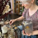 A woman filling a var with apothecary ingredients