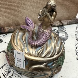 A mermaid atop a small box