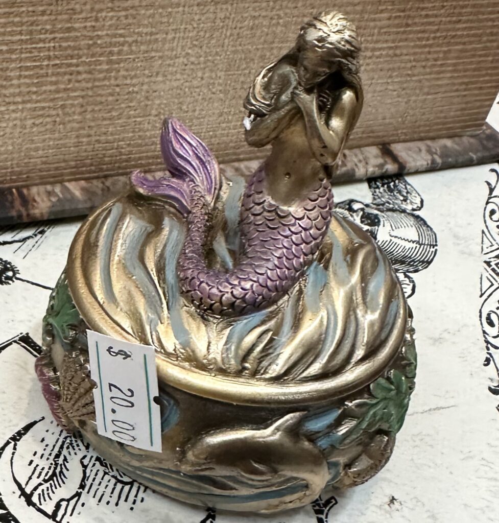 A mermaid atop a small box